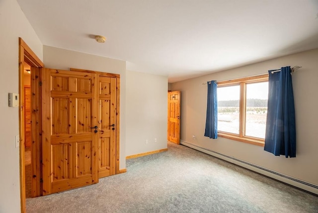 carpeted empty room featuring baseboards and a baseboard radiator