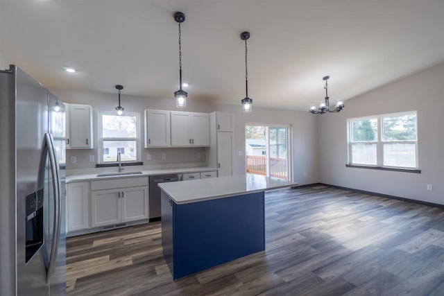 kitchen featuring appliances with stainless steel finishes, light countertops, lofted ceiling, and a sink