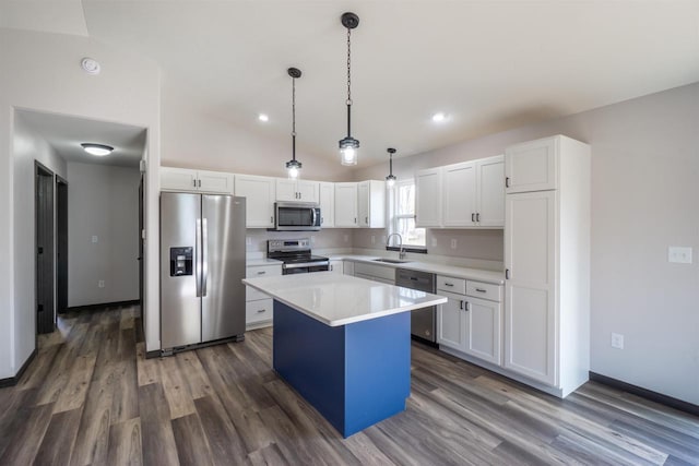 kitchen with a sink, stainless steel appliances, light countertops, white cabinets, and a center island