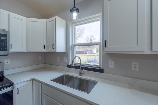 kitchen featuring light countertops, white cabinets, stainless steel appliances, and a sink