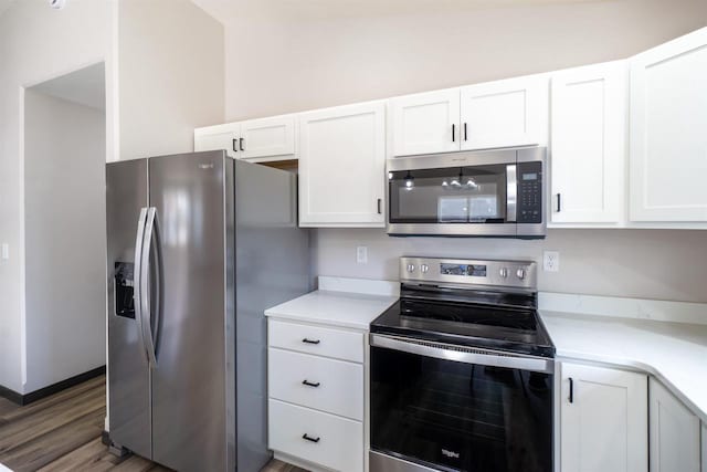 kitchen featuring stainless steel appliances, white cabinets, and light countertops