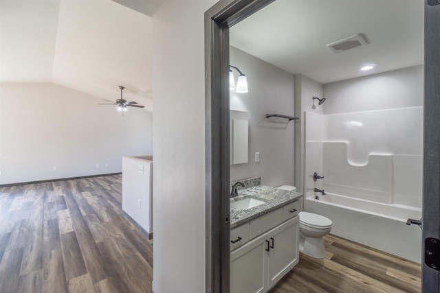 bathroom featuring visible vents, toilet, shower / bathtub combination, wood finished floors, and vanity