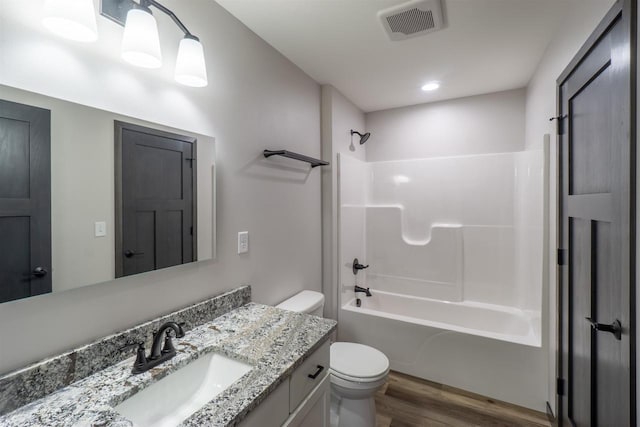 bathroom featuring visible vents, toilet, shower / bathing tub combination, wood finished floors, and vanity