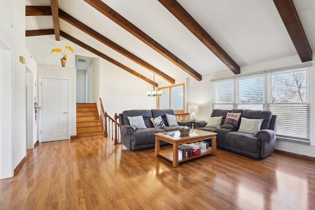 living area featuring a notable chandelier, stairway, light wood-type flooring, and lofted ceiling with beams