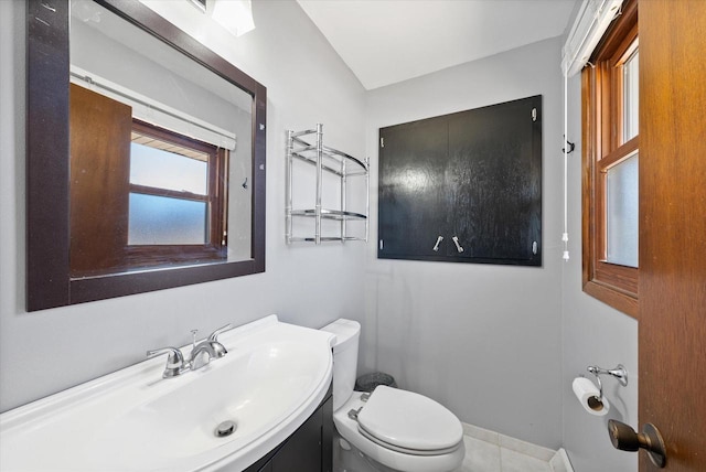 bathroom featuring toilet, vanity, and baseboards