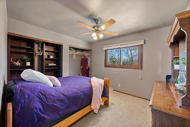 bedroom with a ceiling fan, carpet, baseboards, and two closets