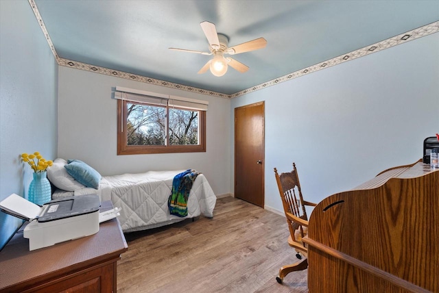 bedroom featuring light wood-style flooring, baseboards, and ceiling fan