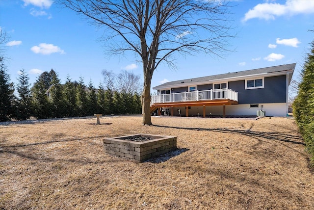 rear view of house featuring a wooden deck, a fire pit, and cooling unit