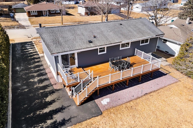 rear view of property featuring a wooden deck, a residential view, and roof with shingles