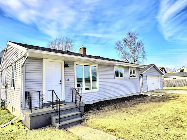 ranch-style home with a chimney, a detached garage, and fence