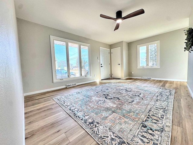 living area with visible vents, baseboards, and wood finished floors