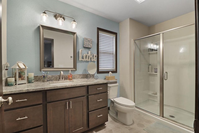 bathroom featuring vanity, tile patterned floors, toilet, and a stall shower