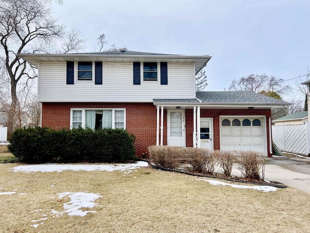 view of front of house with driveway, fence, a front yard, a garage, and brick siding