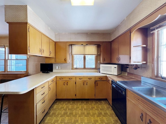 kitchen with dishwasher, light countertops, white microwave, and wallpapered walls