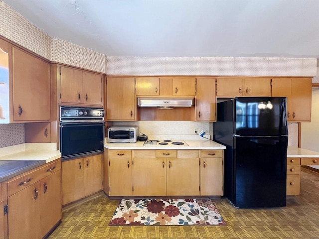 kitchen featuring under cabinet range hood, a toaster, black appliances, and wallpapered walls