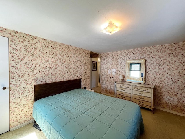 bedroom with light colored carpet, wallpapered walls, and baseboards