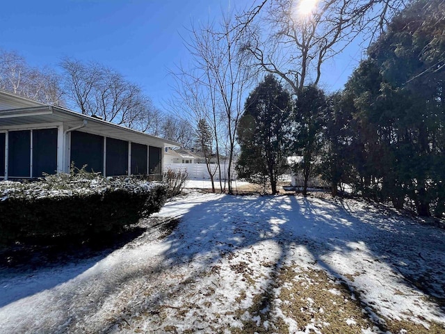 snowy yard featuring a sunroom