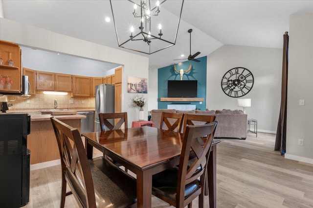 dining room with lofted ceiling, light wood-style flooring, a ceiling fan, and baseboards