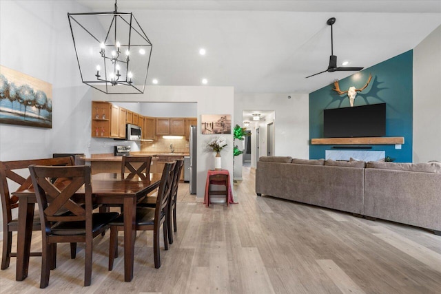 dining space with a ceiling fan, light wood-type flooring, and a towering ceiling