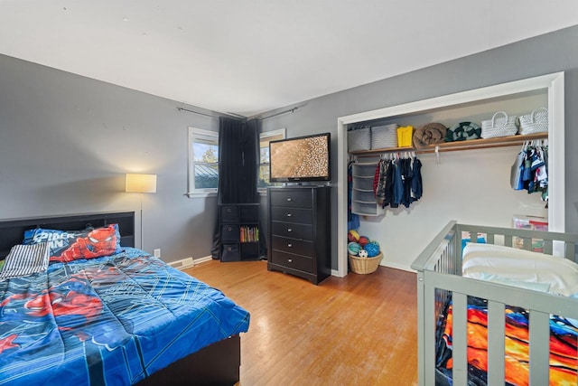 bedroom featuring a closet, baseboards, and wood finished floors