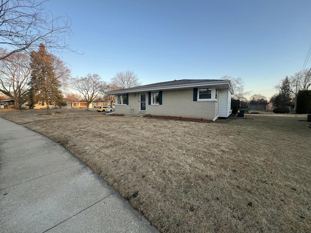 view of front of house featuring brick siding and a front lawn