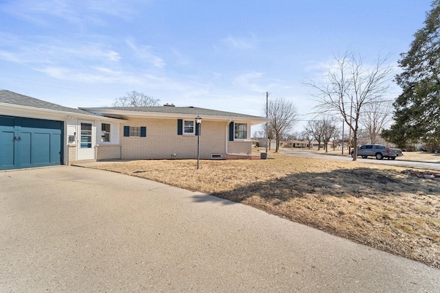 ranch-style home with an attached garage, brick siding, and driveway