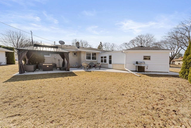 rear view of house featuring a gazebo, a yard, a patio area, and brick siding