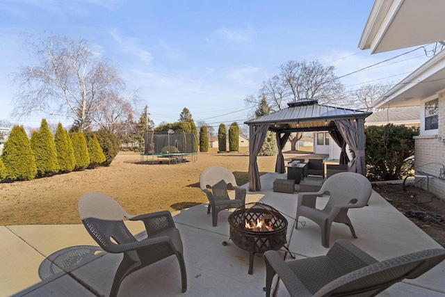 view of patio with a gazebo, a fire pit, and a trampoline