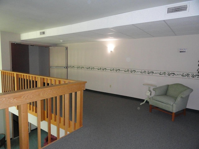 interior space featuring visible vents, a paneled ceiling, carpet floors, and baseboards