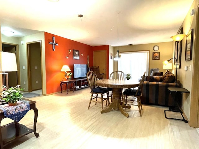 dining room with baseboards and light wood-style flooring