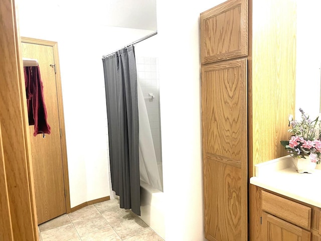 full bath featuring vanity, baseboards, shower / bath combo, and tile patterned flooring