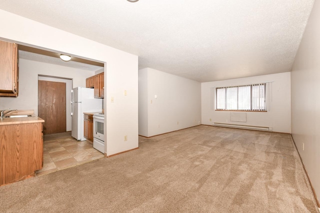 unfurnished living room with baseboard heating, light colored carpet, a textured ceiling, and a sink