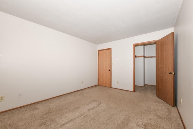 unfurnished bedroom featuring light colored carpet and baseboards