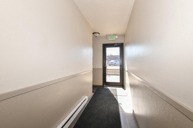 doorway with a wainscoted wall and a baseboard radiator