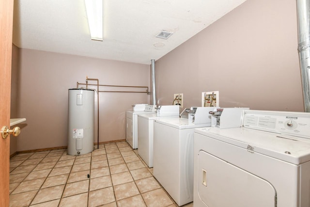 laundry area with light tile patterned floors, visible vents, water heater, and washer and clothes dryer