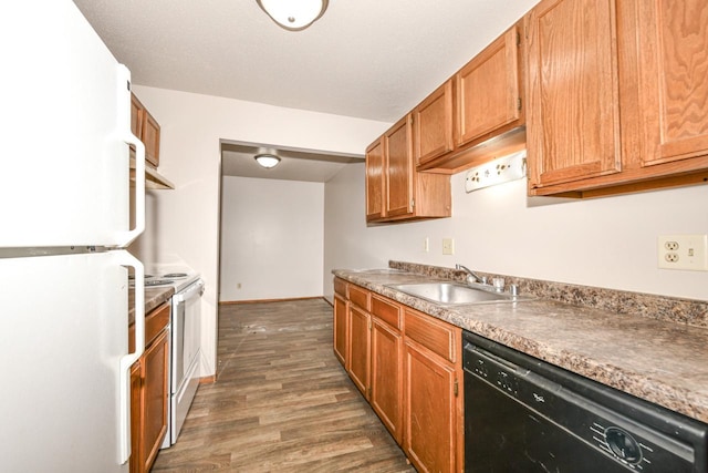 kitchen featuring white appliances, brown cabinetry, wood finished floors, baseboards, and a sink