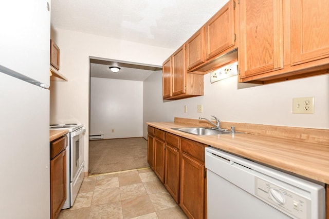 kitchen featuring white appliances, a sink, light countertops, a baseboard heating unit, and light colored carpet