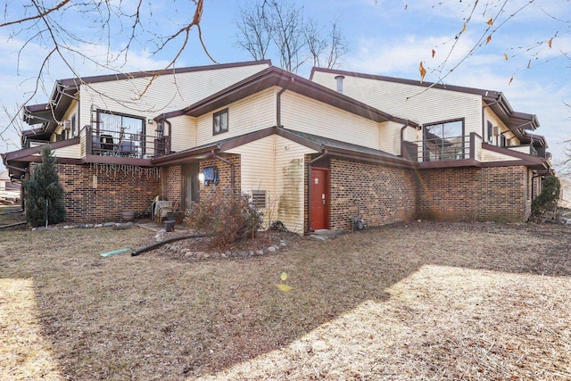 view of property exterior with brick siding and a balcony