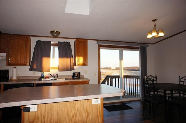 kitchen with dark wood-style floors, ornamental molding, a sink, light countertops, and brown cabinets