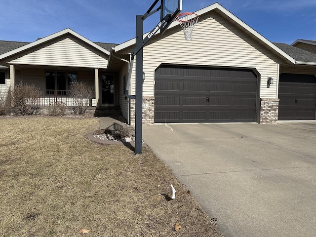 ranch-style home with concrete driveway, an attached garage, covered porch, and brick siding