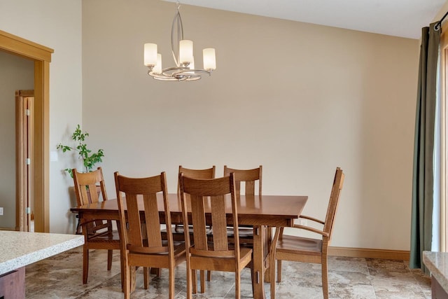 dining space with baseboards and a notable chandelier