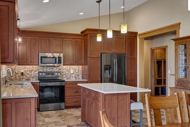 kitchen featuring vaulted ceiling, brown cabinets, appliances with stainless steel finishes, and a sink