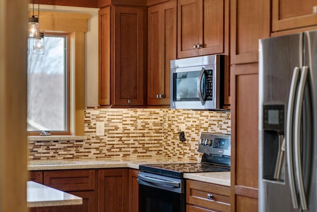 kitchen featuring tasteful backsplash, appliances with stainless steel finishes, and brown cabinetry