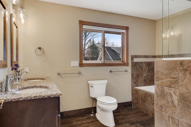 bathroom featuring a sink, baseboards, toilet, and wood finished floors