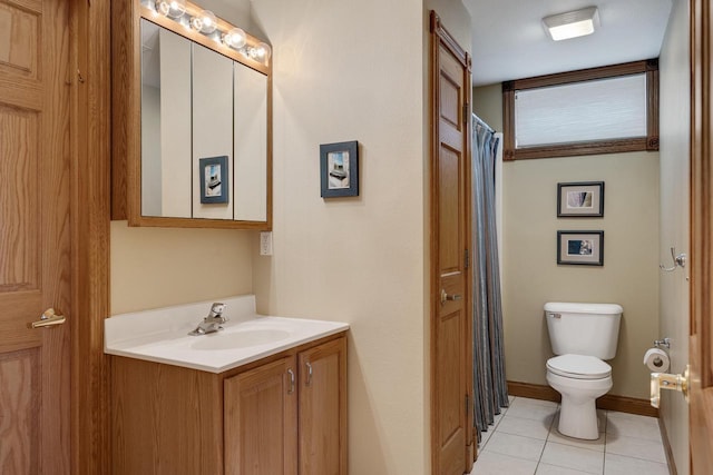 bathroom featuring vanity, toilet, baseboards, and tile patterned flooring