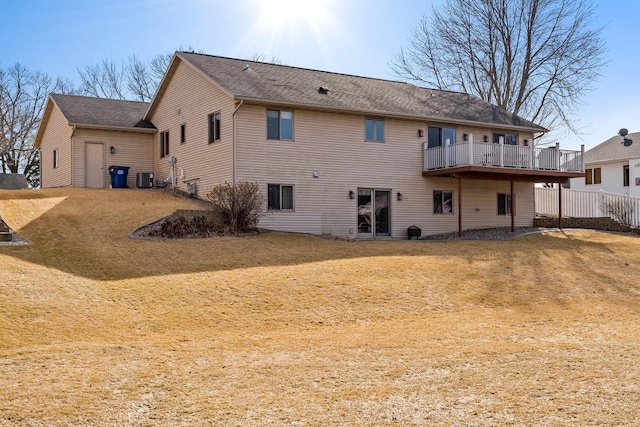 rear view of property with central AC unit, a shingled roof, and a yard