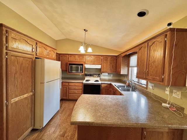 kitchen featuring stainless steel microwave, range with electric cooktop, a peninsula, freestanding refrigerator, and a sink