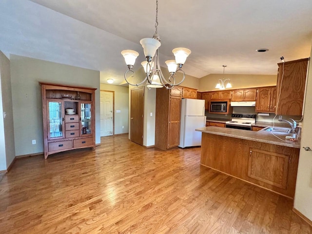 kitchen with a sink, under cabinet range hood, white appliances, brown cabinetry, and a chandelier