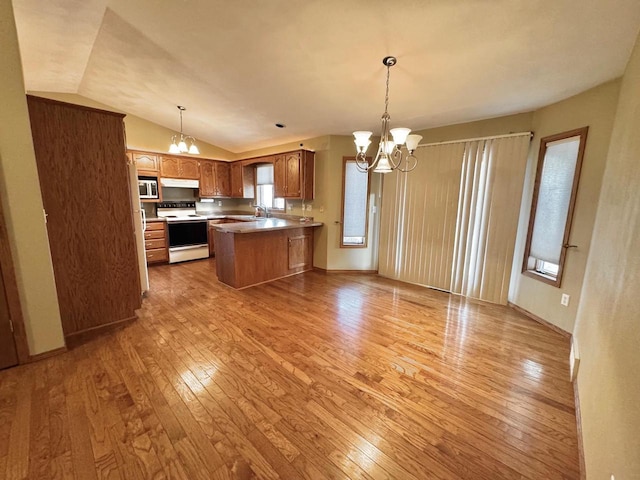 kitchen featuring under cabinet range hood, light wood-type flooring, electric range, a peninsula, and a notable chandelier