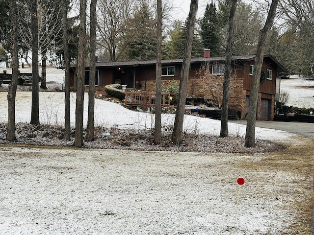 view of front of house with a garage, driveway, and a chimney